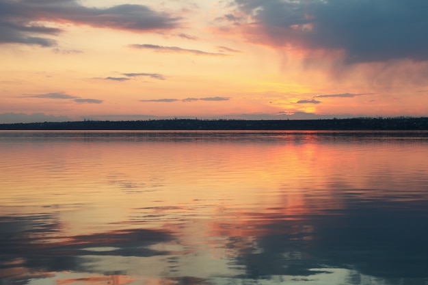 Foto impresionante puesta de sol con nubes y río. naturaleza