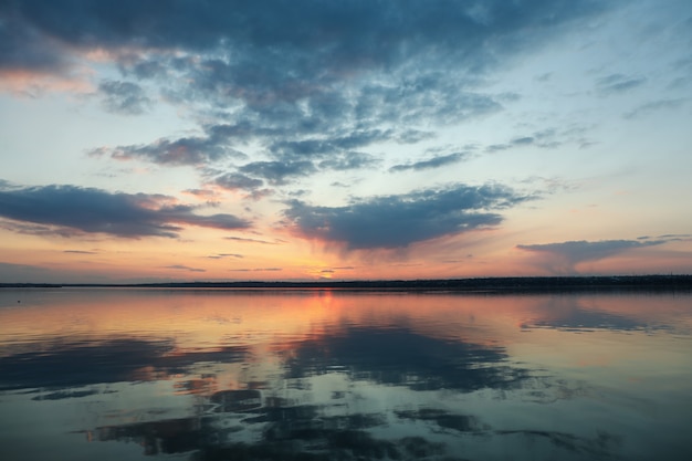 Impresionante puesta de sol con nubes y río. Naturaleza