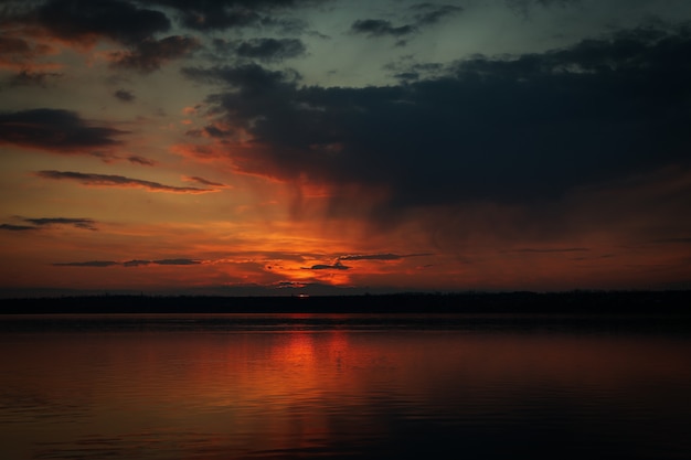 Impresionante puesta de sol con nubes y río.