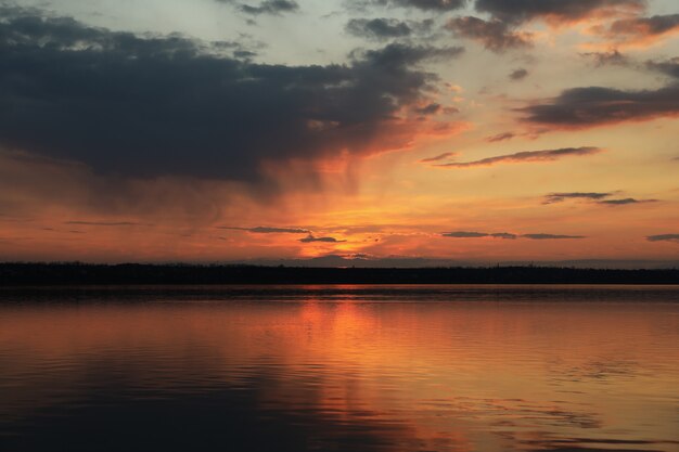 Impresionante puesta de sol con nubes y río.