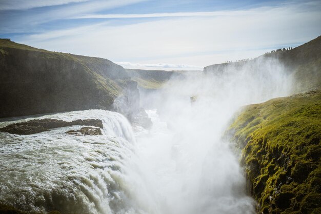 Impresionante vista de las cataratas Gullfoss bajo el cielo azul nublado en Islandia