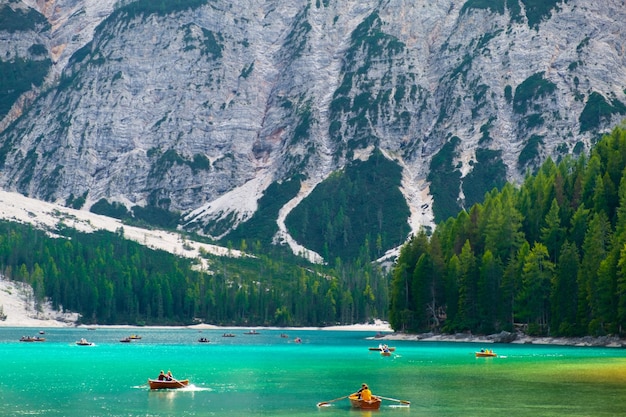 Impresionante vista del lago Braies o Lago di Braies con turistas en botes de madera