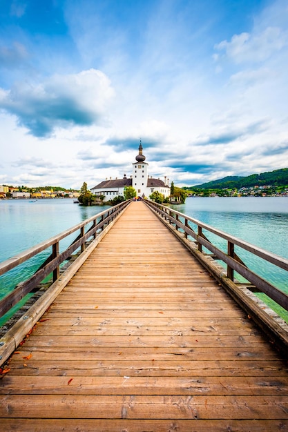 Foto impresionante vista del puente de madera hacia el castillo de schloss ort y el paisaje alrededor en gmunden austria