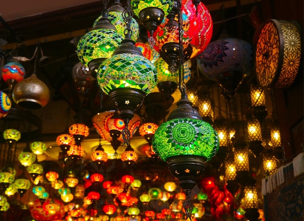 Impresionantes lámparas colgantes de mosaico multicolor de estilo árabe en el cuarto oscuro