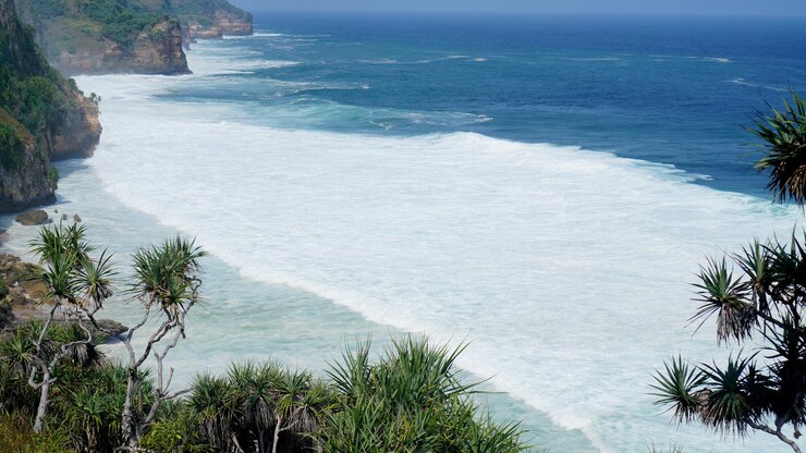 Impresionantes vistas a la playa y altos acantilados en el borde de la playa Olas rodantes y espuma blanca