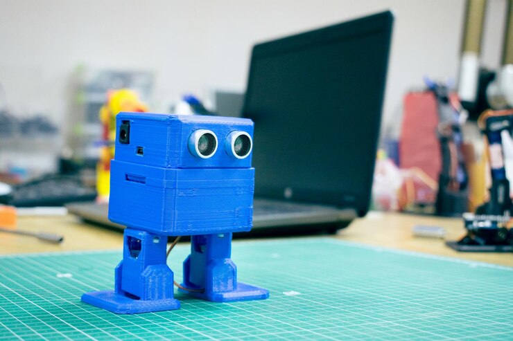 Foto impreso en 3d gracioso robot azul bailando en el fondo de los dispositivos y la computadora portátil