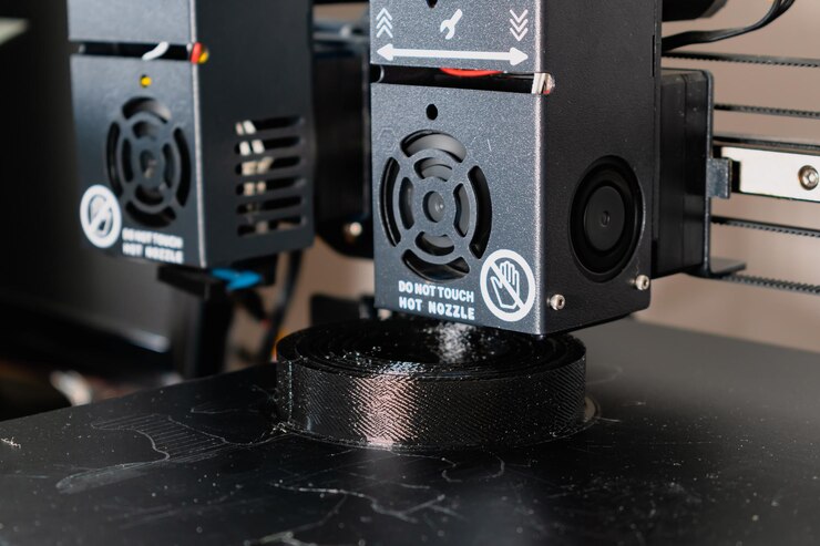 Foto impresora 3d de doble extrusora que imprime un modelo negro con tecnología idex