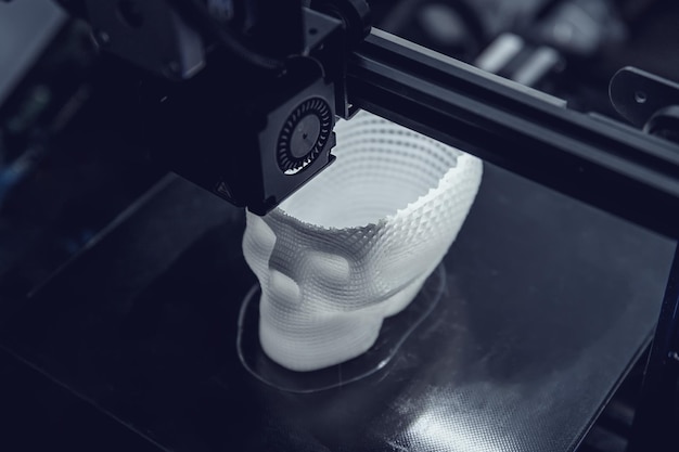 La impresora 3D imprime un modelo de plástico blanco