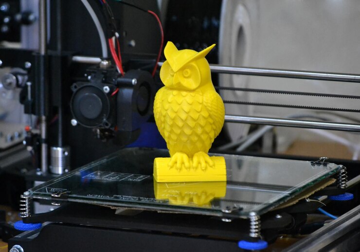 Foto impresora 3d imprimiendo figura amarilla primer plano
