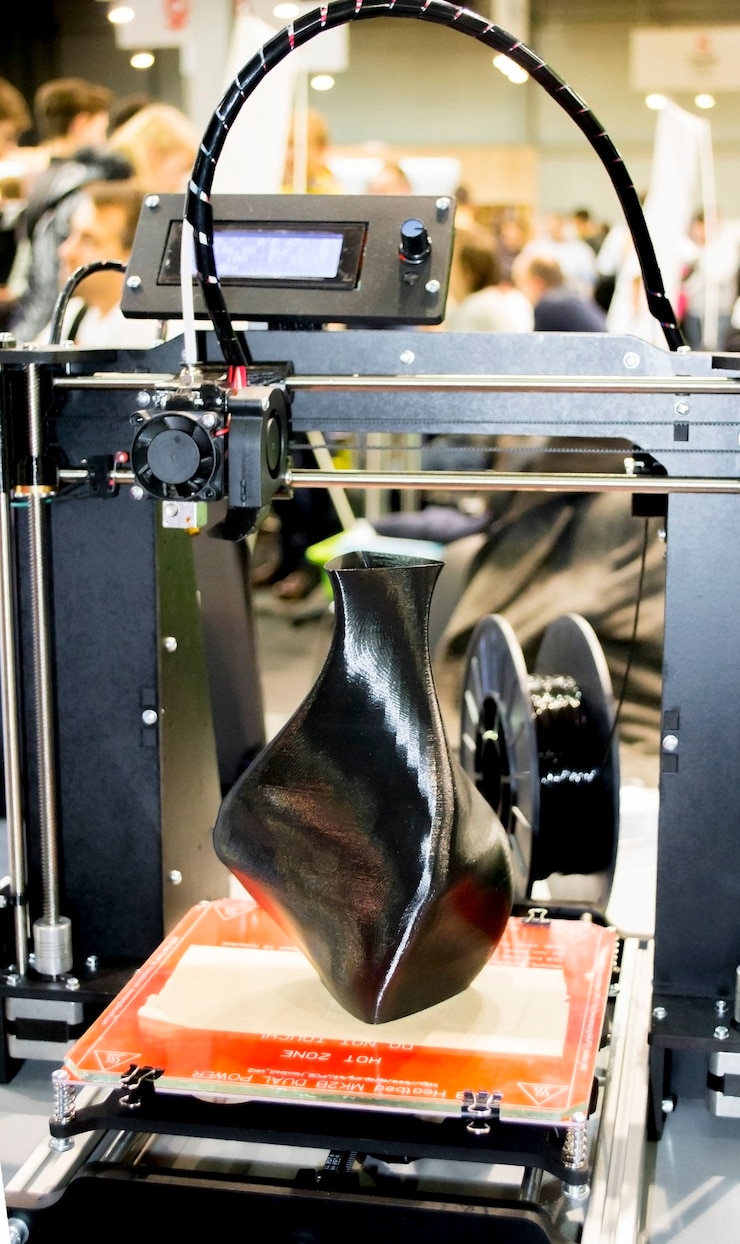 Foto impresora 3d que imprime un modelo en forma de primer plano de jarrón negro. el concepto tecnología aditiva moderna. la 4ta revolución industrial.