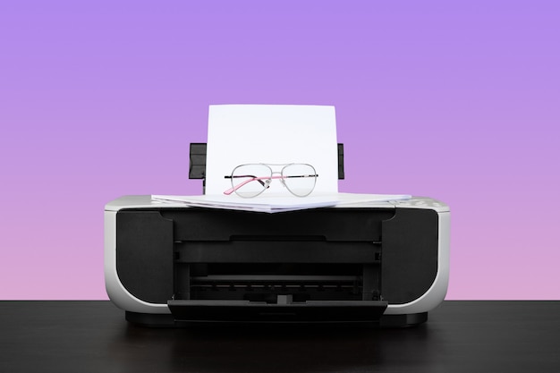 Foto impresora láser para el hogar en el escritorio con fondo violeta