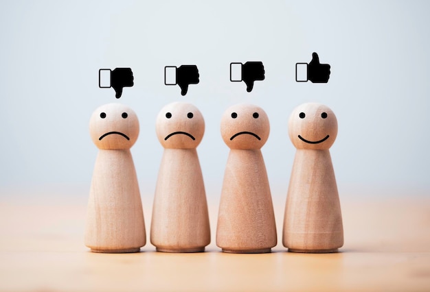 Foto impressão de tela de rosto de sorriso na figura de madeira entre figuras de tristeza para avaliação de serviço ao cliente e conceito de mentalidade emocional.