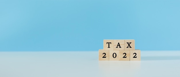 Impuesto 2022 palabra sobre bloques de cubo de madera fondo azul contabilidad finanzas economía ingresos pago de impuestos concepto con espacio de copia
