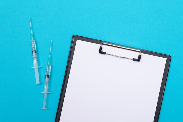 Imunologia de vacinação ou conceito de revacinação duas seringas médicas deitado na mesa azul em médicos ...