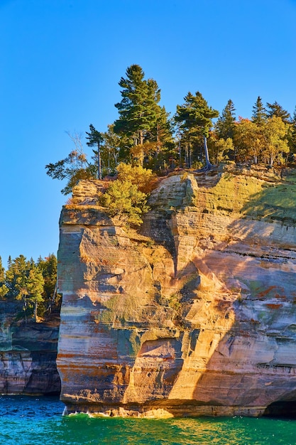 In das grüne Meerwasser ragt eine Klippe im abgebildeten Rocks-Nationalpark Michigan