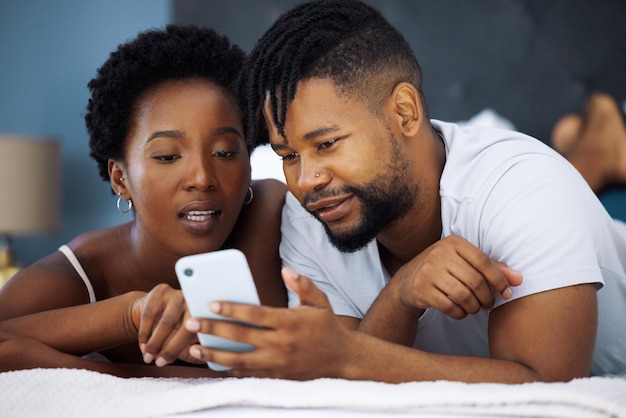 In dem Moment, als wir uns trafen, knüpften wir eine lebenslange Verbindung Aufnahme eines jungen Paares, das zu Hause im Bett ein Smartphone benutzt