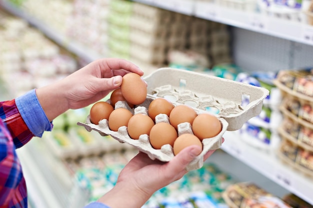 Foto in den händen einer frau, die im supermarkt eier verpackt