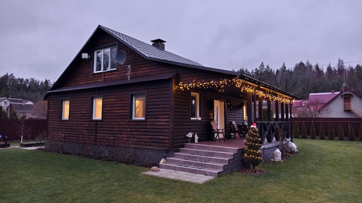 Foto in der abenddämmerung am heiligabend werden auf der terrasse des holzhauses girlanden angezündet