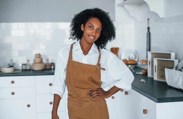 In der Küche Junge afroamerikanische Frau mit lockigem Haar drinnen zu Hause