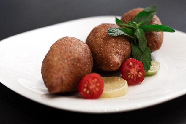 In der levantinischen Küche wird Kibbeh normalerweise durch Stampfen von Bulgurweizen zusammen mit Fleisch hergestellt