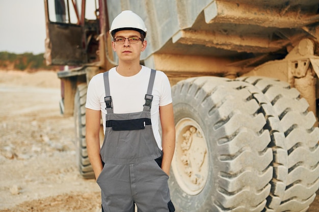 In der Nähe des Ladefahrzeugs Arbeiter in Berufsuniform ist tagsüber auf der Leihgrube