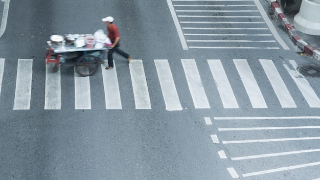 In der Seitenansicht laufen Menschen und der Straßenküchenwagen schnell rüber.