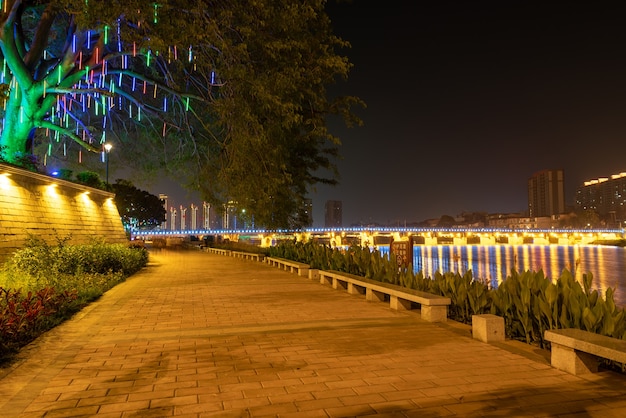 In der Stadt bei Nacht spiegeln sich bunte Lichter im Wasser des Flusses