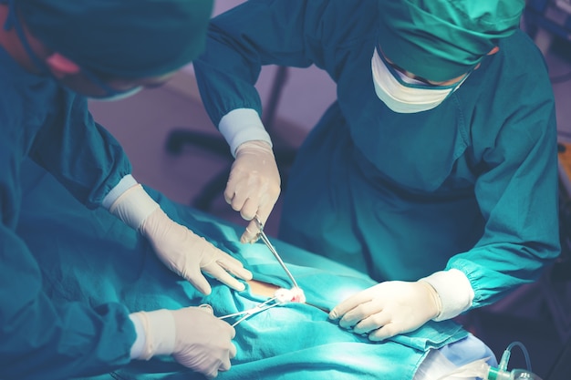 In einem anspruchsvollen Operationssaal operiert ein asiatischer Arzt.