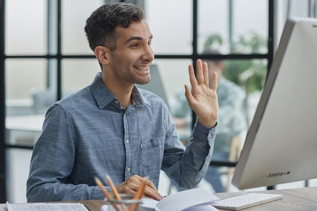 In einem großen, vielfältigen Firmenbüro Porträt einer schönen Managerin, die einen Desktop-Computer benutzt