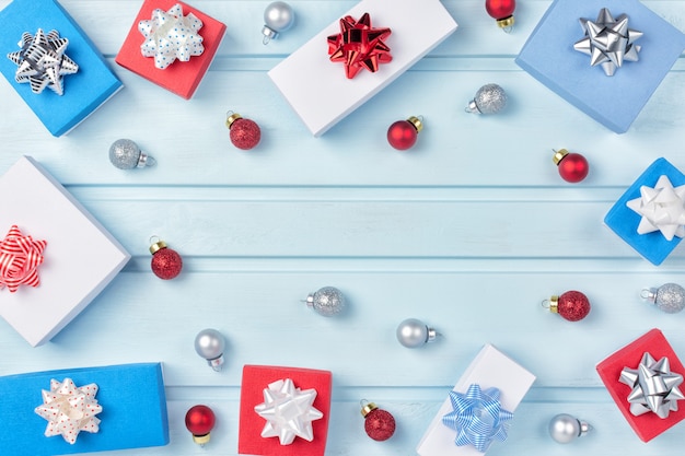 In einem Kreis mit blauem Hintergrund befinden sich rote und silberne Weihnachtskugeln, Geschenkboxen mit Schleifen. Weihnachtszusammensetzung, Rahmen. Kopieren Sie Platz. Festliches Layout.