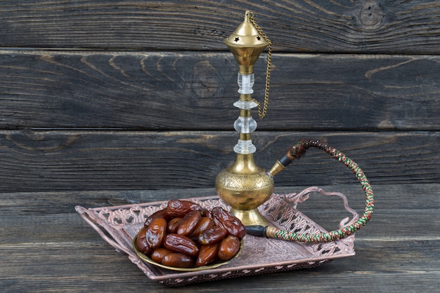 in einer Bronzeplatte Datteln und Shisha. Ramadan Kareem.