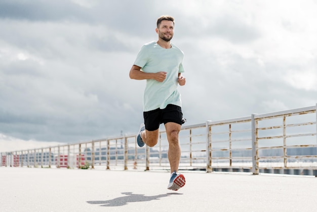 In Fitnesskleidung ist der Athlet eine schnelle Laufbewegung. Männlicher Lauftrainer trainiert das Fitnessleben