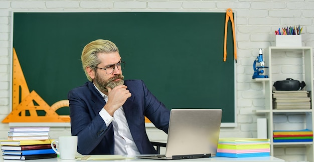 In Gedanken versunken Ernster Mann zurück in die Schule Leitender Lehrer schaut ernst in Brille Business Coach denkt mit ernstem Gesicht Tiefsinniger Denker Schule und Bildung Ernst und nachdenklich