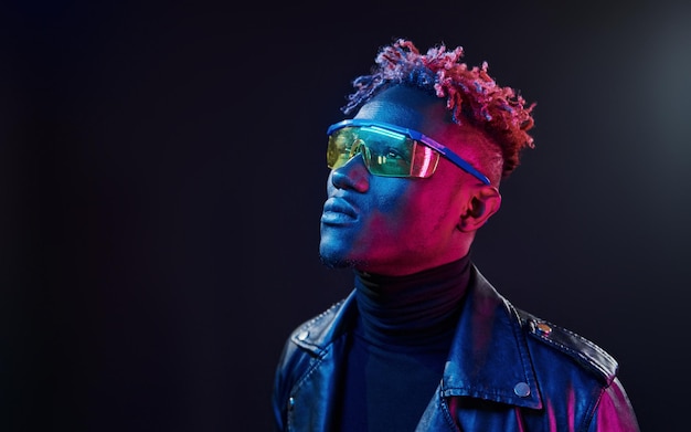 In Gläsern Futuristische Neonbeleuchtung Junger afroamerikanischer Mann im Studio