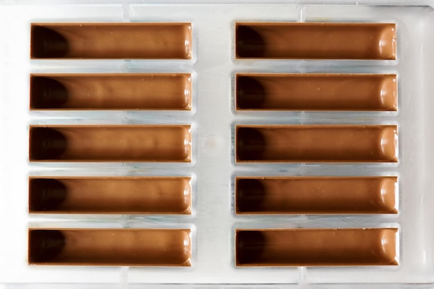 In Kunststoffformrahmen gegossene Schokolade zum Füllen von Schokoriegeln