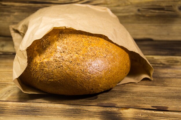 Foto in papier verpacktes brot auf einem holztisch