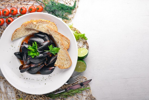 Foto in sauce gekochte muscheln auf einem hölzernen hintergrund ansicht von oben freier platz für ihren text