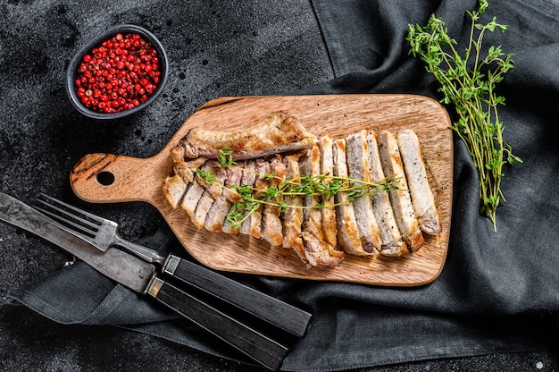 In Scheiben geschnitten Gegrillte Schweinekoteletts. Bio-Fleischsteak. Schwarzer Hintergrund. Draufsicht