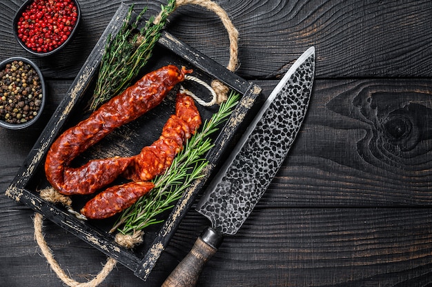 In Scheiben geschnittene Chorizo-Salami, traditionelle spanische Chorizo-Wurst. Schwarzer hölzerner Hintergrund. Ansicht von oben. Platz kopieren.