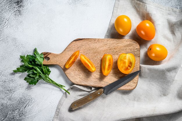 In Scheiben geschnittene frische gelbe Kirschtomate auf einem Schneidebrett