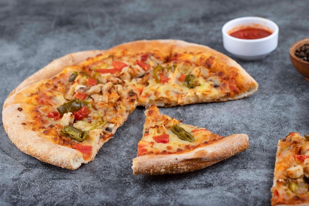 In Scheiben geschnittene heiße leckere Pizza auf einen Steintisch gelegt.