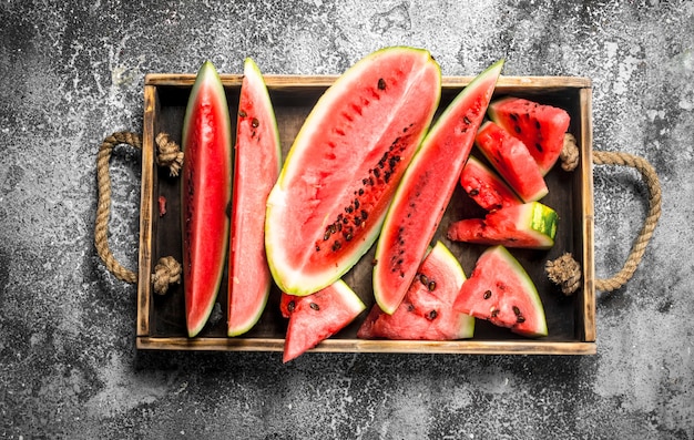 In Scheiben geschnittene reife Wassermelone auf einem Holztablett