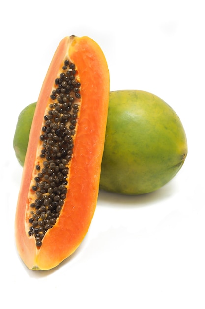 In Scheiben geschnittene und ganze frische Bio-Papaya, köstliche Frucht, Seitenansicht isoliert auf weißem Hintergrund