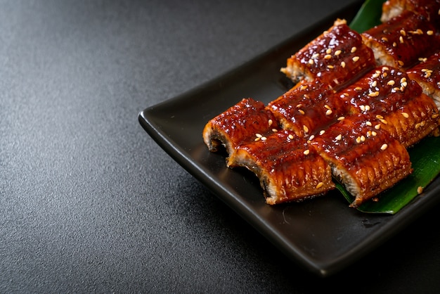 In Scheiben geschnittener gegrillter Aal oder gegrillter Unagi mit Sauce (Kabayaki) - japanischer Essensstil