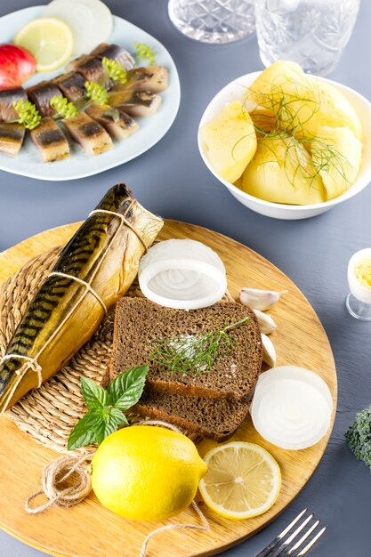 In Scheiben geschnittener gesalzener Fisch mit Zitrone und Gewürzen, Salzkartoffeln auf einem Tisch