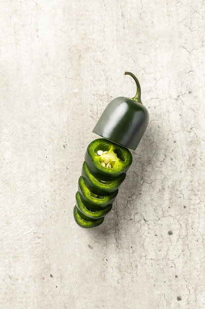 In Scheiben geschnittener grüner Jalapeno-Pfeffer auf alter Tischplatte