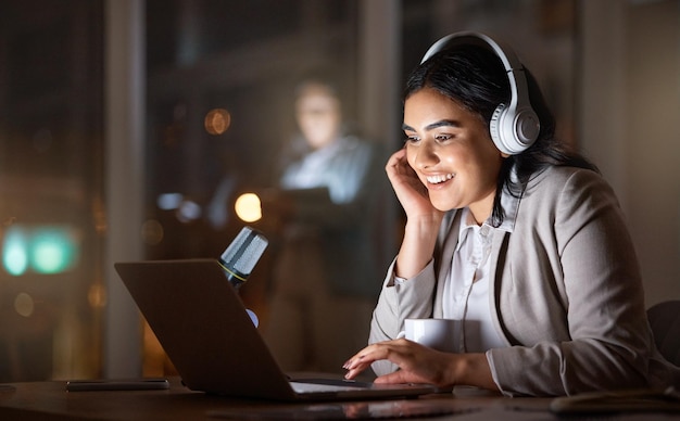 In späten Nächten ist Musik die beste Gesellschaft. Schnappschuss einer attraktiven jungen Geschäftsfrau, die bis spät in die Büros ihrer Firma arbeitet.