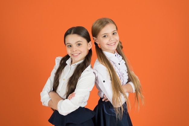 In traditionellem Schwarz und Weiß Kleine Mädchen in Schuluniform Schulkinder mit modischem Blick Nette Schulmädchen Kleine Mädchen in Zöpfen für die Schule gekleidet Back to school fashion