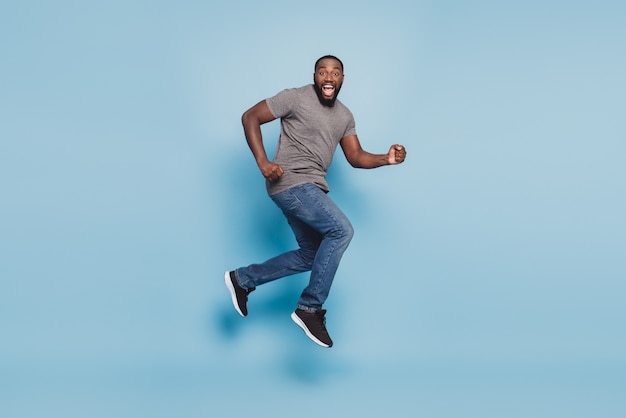 In voller Länge Ansicht des Afro-Typen, der isoliert auf blauem Hintergrund springt