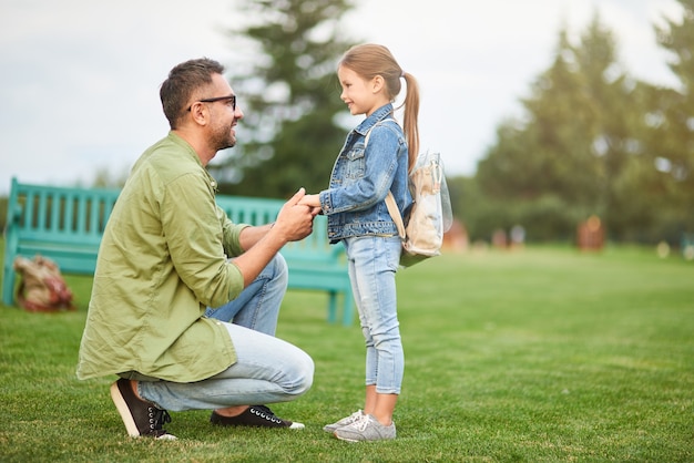 In voller Länge Aufnahme eines glücklichen jungen Vaters, der die Hände der Tochter hält, Papa, der Zeit mit seinem süßen